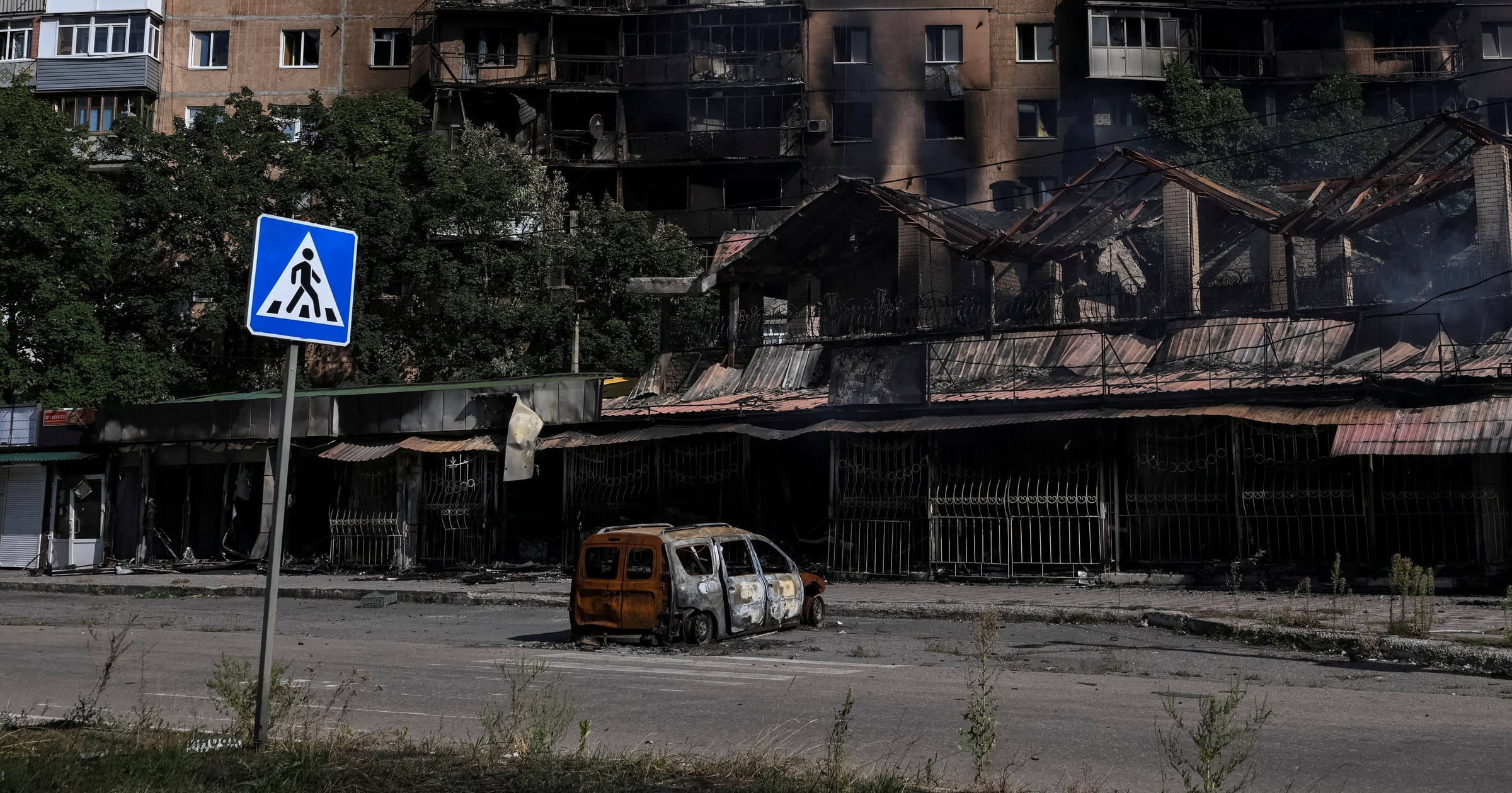 Burned out cars, rubble from flattened buildings strewn along deserted streets