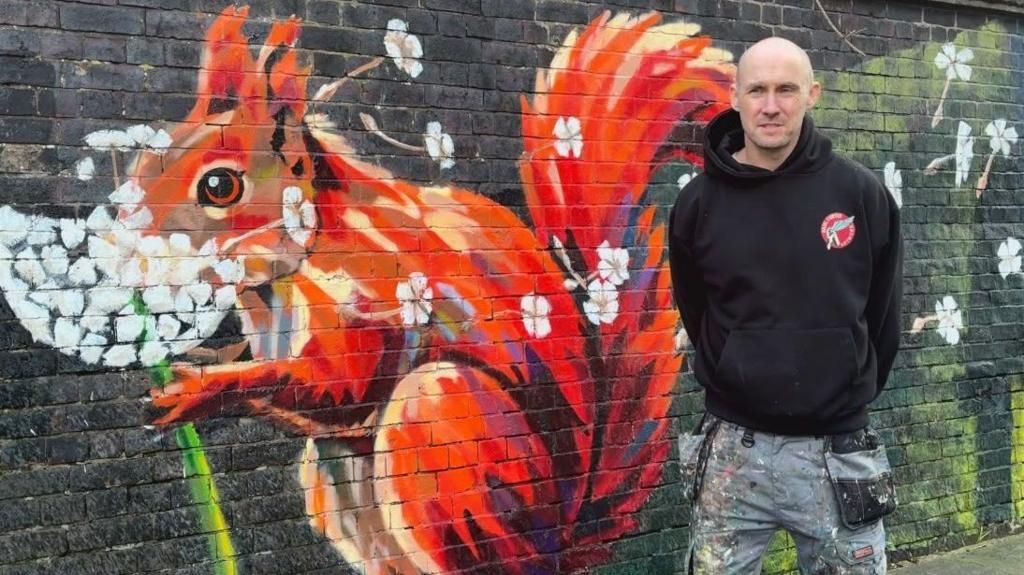 Artist unveils 525ft mural inspired by pupils