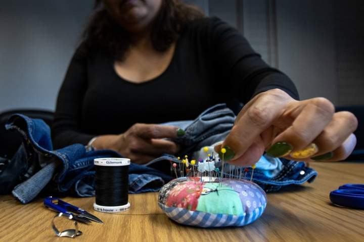 ‘Stitched it back’: Edmonton event where locals mend clothes promotes sustainability
