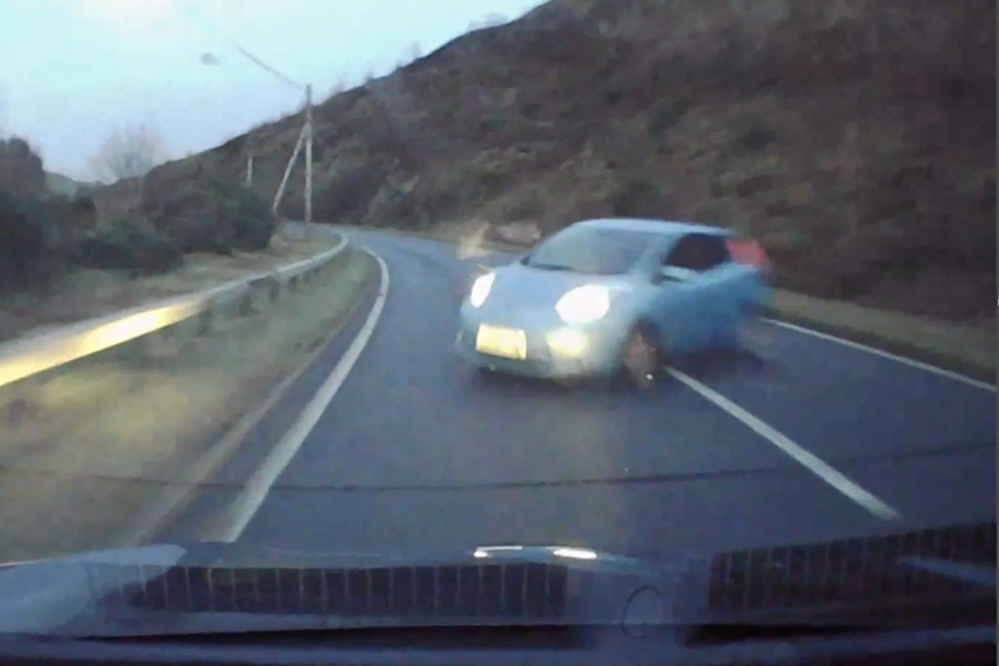 Terrifying moment out-of-control car hurtles towards driver before smashing into him head-on after speeding around bend