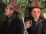 Johnny Depp BITES leaves off foliage backdrop as he raises toast at drinks festival in Las Vegas