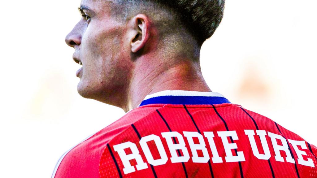 Why does Robbie Ure have Robbie Ure on his Scotland shirt?