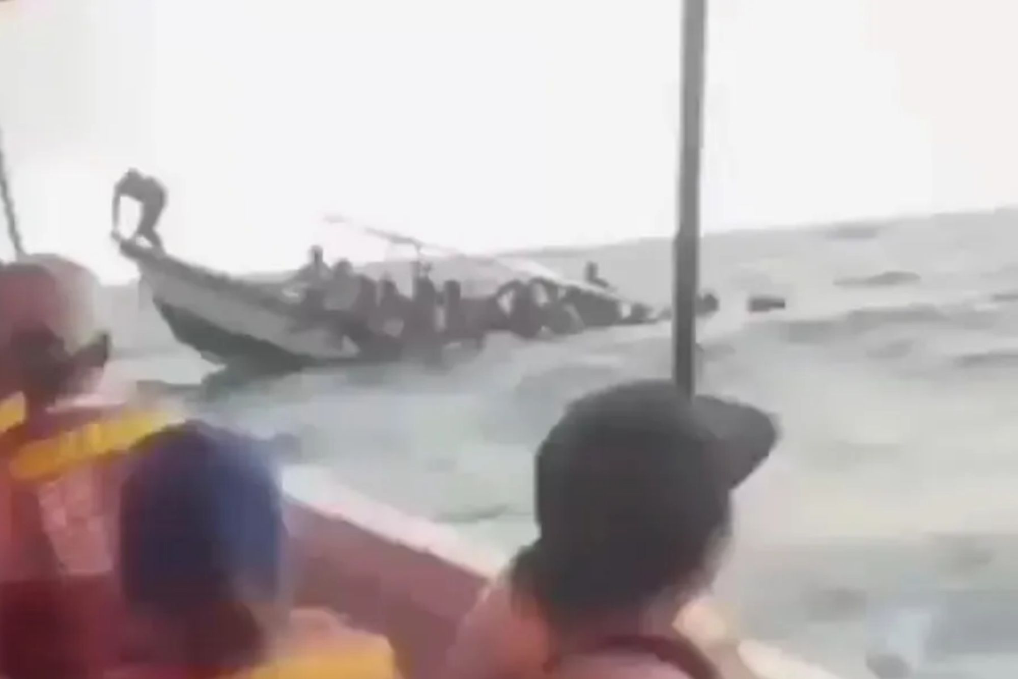 Shocking moment packed tourist boat capsizes in rough seas throwing terrified passengers into choppy waters