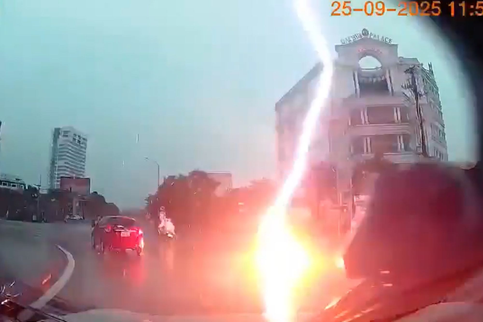 Horrifying moment woman is struck by lightning and crashes to the ground while riding motorbike in middle of junction