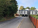 Moment police cause outrage by 'escorting' a static caravan onto an illegal site where travellers paved over a village's protected field