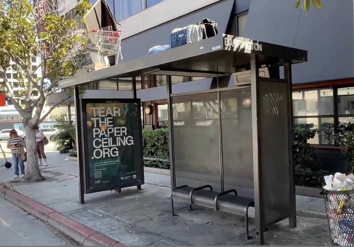 Man makes camp, with his shopping cart, atop Brentwood bus stop shelter