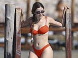 Retired Instagram model Demi Rose flaunts her famous curves in an orange bikini as she soaks up the sun in Ibiza