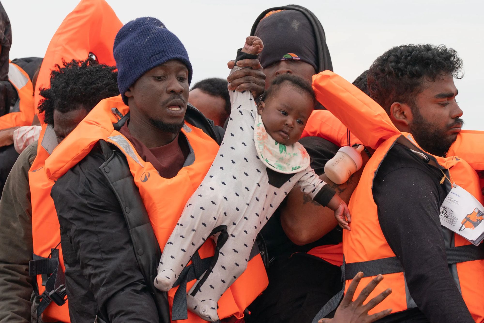Months-old baby seen being hauled onto Channel migrant mega-dinghy to UK – as French police stand by and do nothing