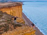 Teenage boy risks his life by posing for photo on edge of 150ft crumbling cliffs made famous by Broadchurch - despite safety warnings over massive rockfall