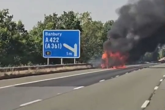 Shocking moment car bursts into flames on busy UK motorway sending plumes of black smoke billowing across three lanes