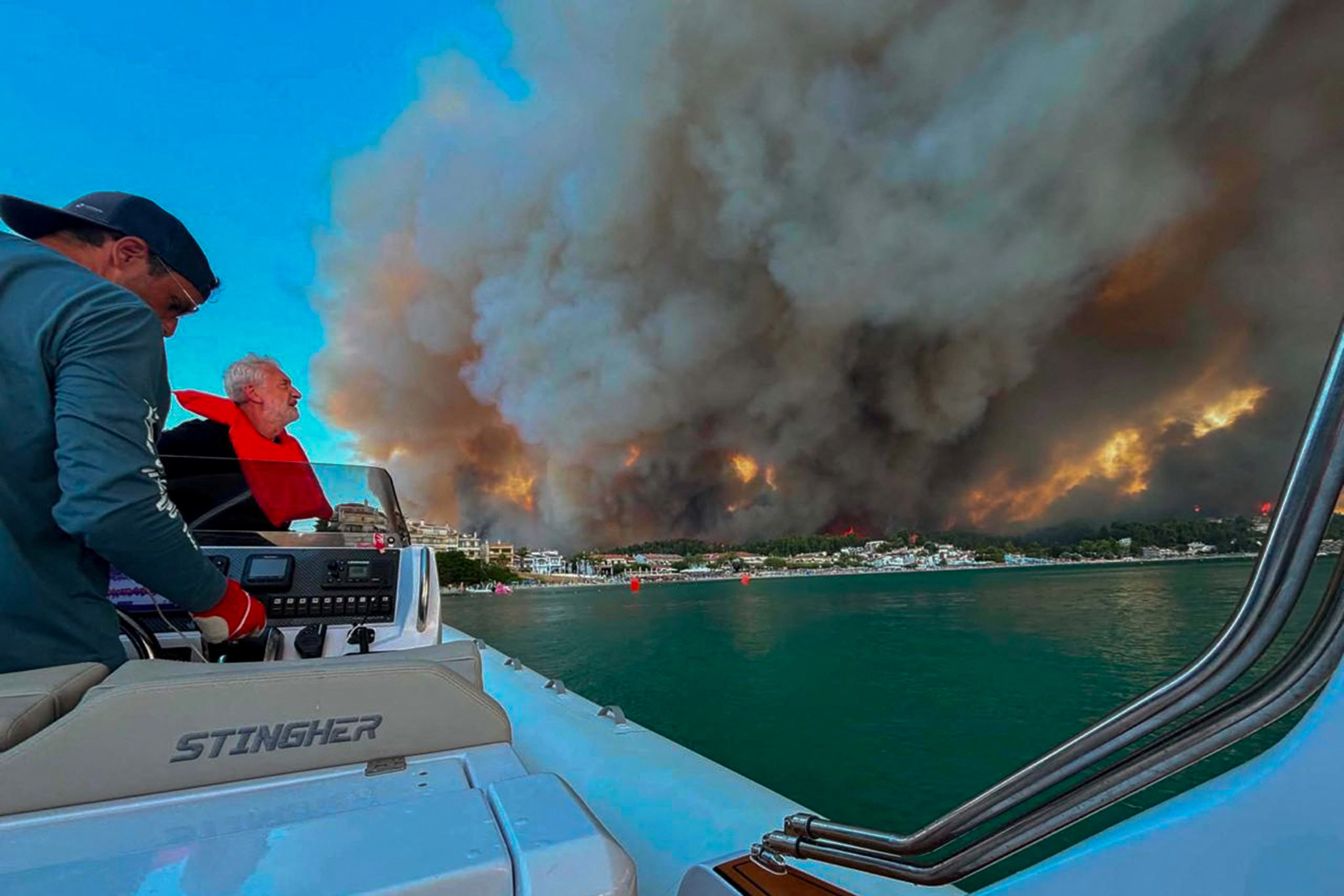 Hundreds of tourists rescued by boats fleeing resorts in Greece as ‘wall of flame’ wildfire rages & threaten beaches