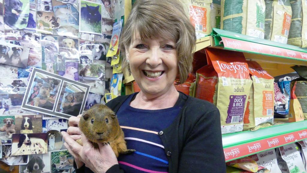 Hundreds line street - with dogs - for pet shop owner's funeral