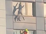 Hair-raising moment woman hangs from 11th floor of burning building before making daring jump to safety
