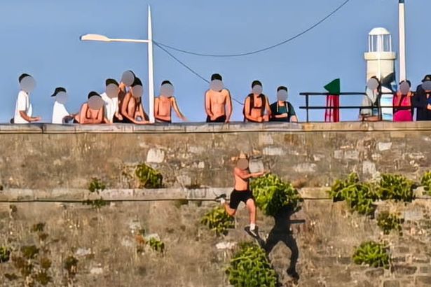 Youngsters seen tombstoning from dangerous 65ft cliff known as 'Dead Man's Cove' where dad plunged to death