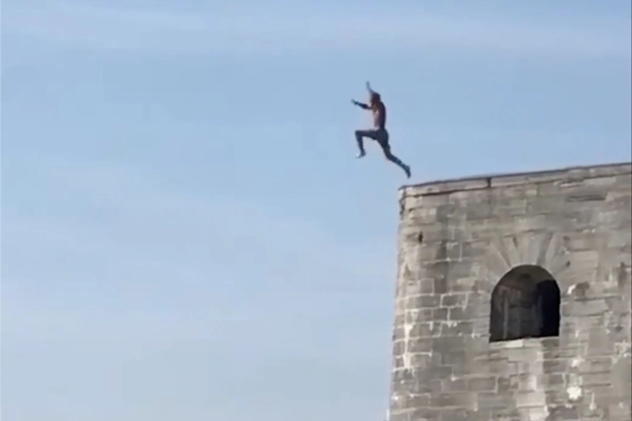 Moment idiots ‘tombstone’ into shallow water from 20ft castle walls at UK beach as cops warn ‘you’re risking your life’